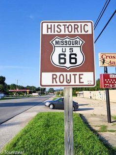 a sign that is on the side of a road in front of a car and some signs