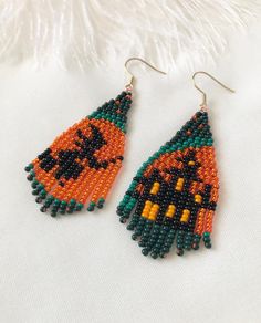 the beaded earrings are decorated with orange and green beads