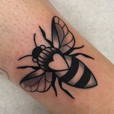 a black and white bee tattoo on the arm