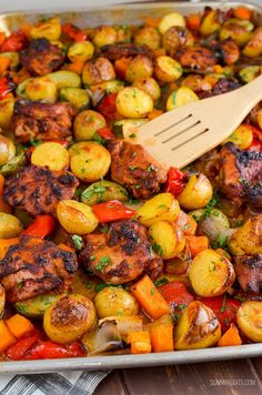 a pan filled with meat and vegetables on top of a wooden table