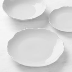 three white dishes sitting on top of a table