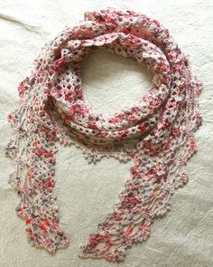 a red and white scarf on top of a bed