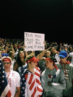 a group of people holding up signs in front of an audience at a sporting event