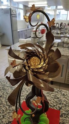 a cake that is decorated with gold and brown decorations on top of a red plate