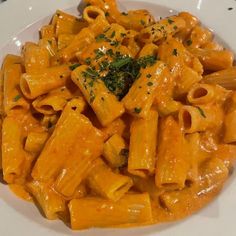 a white plate topped with pasta covered in sauce