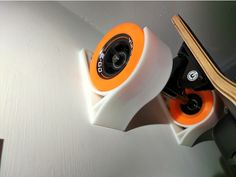 an orange and white skateboard resting on the edge of a wall next to another board