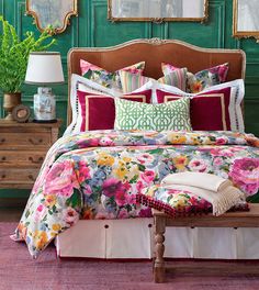 a bedroom with green walls and floral bedding