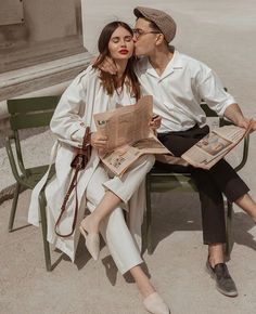 a man and woman are sitting on a bench with newspapers in front of their faces