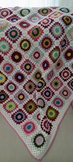 a crocheted granny's afghan is displayed in front of a white window