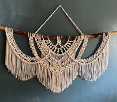 the wall hanging is made with macrame and tassels