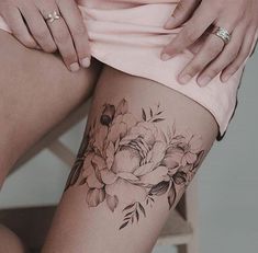 a woman's thigh with a flower tattoo on her left leg and the bottom half of her thighs