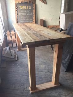 a large wooden table sitting inside of a room next to a sign on the wall