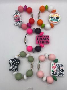 several different colored beads and charms on a white surface with the words don't the damn thing