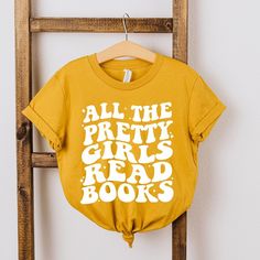 Looking for a cute tee for your kids? We have the perfect Pretty Girls Read Books graphic tee addition to their closet! Also available in toddler tees. Bookish Text Print Tops For School, Bookish Graphic Print Tops For School, School Tops With Graphic Print In Bookish Style, Books Graphic, Casual Street Wear, Girls Graphic Tee, Girl Reading, Toddler Tees, Sleeve Styles