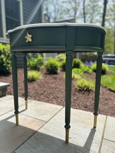 a green table sitting on top of a sidewalk