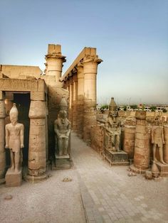 an ancient egyptian temple with statues on the outside