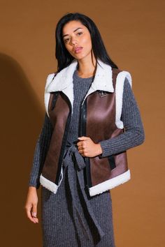 A faux leather/sherpa vest with high neckline and front buckle/zipper closure Details: Self : 100% PolyesterContrast 1 : 100% PolyesterContrast 2 : 100% Polyeurethane Size & Fit - Model is 5`8" And Wearing Size Small- Measurements Taken From Size Small- Approx. Length: 24" Trendy Winter Vest With Zipper Closure, Sleeveless Outerwear With Zipper For Fall, Brown Faux Fur Trim Vest For Fall, Brown Vest With Faux Fur Trim For Fall, Trendy Sleeveless Outerwear With Zipper Closure, Brown Sleeveless Vest With Faux Fur Lining, Trendy Fall Vest With Zipper Closure, Sherpa Vest, In Another Life