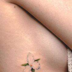 a white flower on the side of a woman's stomach