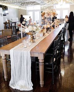 a long wooden table topped with lots of flowers