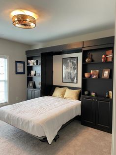 a bed sitting in a bedroom next to a book shelf