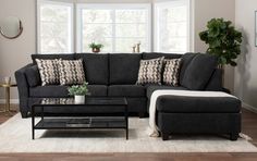 a living room filled with furniture and a rug on top of a hard wood floor