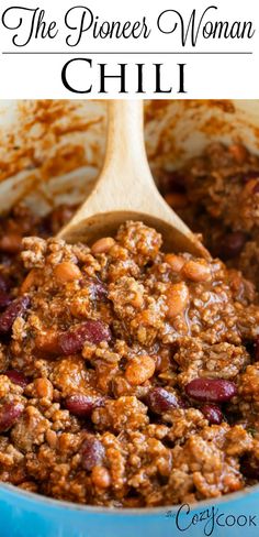 a blue pot filled with chili next to a wooden spoon