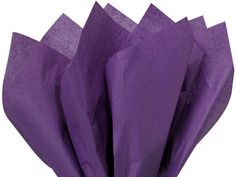 purple tissue paper is folded up on top of each other and placed in front of a white background