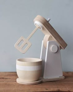 a wooden mixer and bowl sitting on top of a table