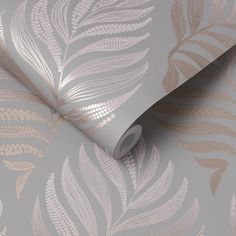 a silver and gold wallpaper with leaves on the side, next to a roll of toilet paper