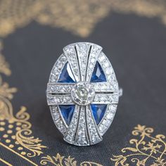 Talk about big and bold! This dinner ring fits that bill perfectly - exquisitely-crafted in the art deco style, the central old European cut diamond is bezel-set in the center, in a geometric surround of old cut diamonds and triangle-shaped natural sapphires. Just stunning details all through-out! A wonderful piece of jewelry to add to one's jewelry suite - its the perfect dinner ring! Platinum, size 8m, and fully sizable.Center diamond is estimated to be .68cts, K color, SI clarity.Additional 1 Dinner Ring, Silver Engagement Ring, Perfect Dinner, Bezel Set Ring, Engagement Ring Vintage, Blue Sapphire Ring, Vintage Style Rings, Sterling Silver Engagement Rings, Round Diamond Engagement Rings