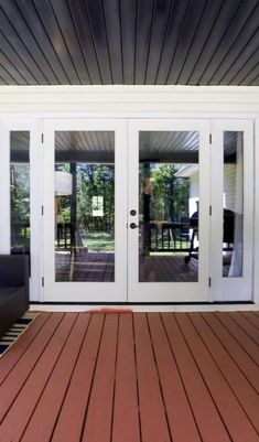 a deck with two couches and sliding glass doors