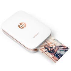 a white hp printer sitting on top of a table next to a piece of paper