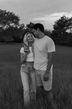 a man and woman standing in the middle of a field