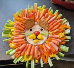 a lion made out of carrots and celery sticks with a cracker in it's mouth