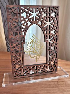 a wooden frame with an arabic calligraphy on the front and sides, sitting on a table