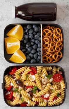 two containers filled with pasta, fruit and pretzels next to a bottle of soda