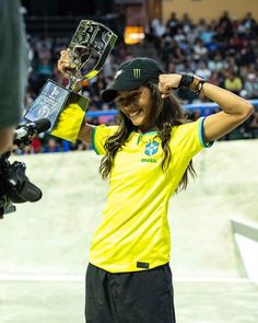 a woman holding up a trophy in front of a crowd