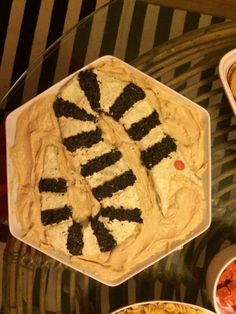 several different types of food in bowls on top of a glass table with black and white stripes