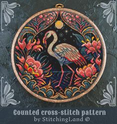 a cross - stitch pattern with a flamingo in the center and flowers around it