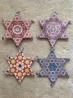 four ornament shaped like stars on the floor in different colors and patterns, each with an individual's own design