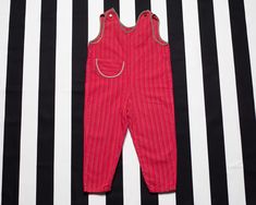 Very cute vintage 70's light summer overalls in pinky red stripes. Made of 100% cotton, and features buttoned straps. Ideal for fun summer activities outside. Vintage condition level: 8/10.* Shows overall wear but nothing in particular. SIZE. Estimated size approx. 12-24 months. To be sure it would fit please check the measurements below.  FLAT Measurements: Side to side: 12'' / 30.5 cm Length: 27'' / 68.5 cm Inseam: 12 1/2'' / 31.5 cm SKU - M56 *We assess the condition of our vintage items on a Summer Bib Front Jumpsuits And Rompers For Playtime, Summer Jumpsuits And Rompers With Bib Front, Playful Red Jumpsuits And Rompers For Summer, Red Cotton Overalls For Summer, Red Retro Jumpsuits And Rompers For Summer, Red Cotton Summer Overalls, Red Summer Overalls With Pockets, Striped Cotton Overall Jumpsuits And Rompers, Summer Striped Cotton Overalls