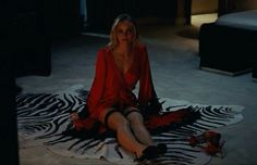 a woman sitting on top of a zebra print rug