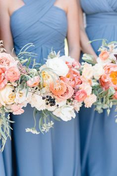 the bridesmaids are wearing blue dresses and holding bouquets with peach flowers on them