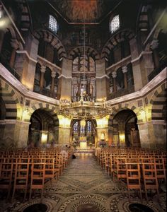 the inside of a church with pews and stained glass windows