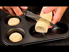 someone is cutting cheese into small muffins in a pan with a large knife