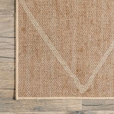 an area rug on top of a wooden floor with a white line in the middle