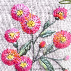 some pink and yellow flowers on a white cloth