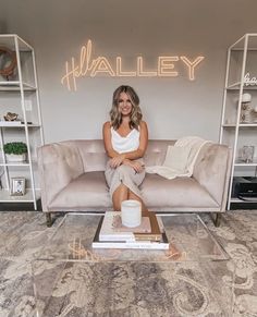 a woman sitting on top of a couch next to a coffee table