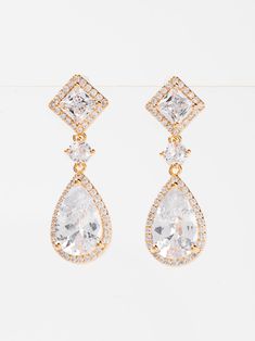 Expertly crafted with white gold plating, these Rhea earrings feature sparkling cubic zirconia drops that will add elegance to any outfit. The perfect balance of style and affordability, these earrings make a dazzling addition to your jewelry collection. SizeL: 1.2" QualityMade with quality materials for endurance. ImportedECZ1552 Glamorous Cubic Zirconia Clip-on Earrings For Anniversary, Diamond White Sparkling Drop Earrings, Dazzling Crystal Earrings With Diamond Accents, Glamorous Diamond Drop Earrings With Elegant Design, Dazzling Cubic Zirconia Drop Earrings, Glamorous Elegant Drop Diamond Earrings, Dangle Earrings With Diamond Accents And Cubic Zirconia, Glamorous Diamond Drop Earrings With Prong Setting, Classic Cubic Zirconia Chandelier Earrings With Elegant Design