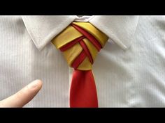 a man wearing a white shirt and red tie with gold strips on the necktie